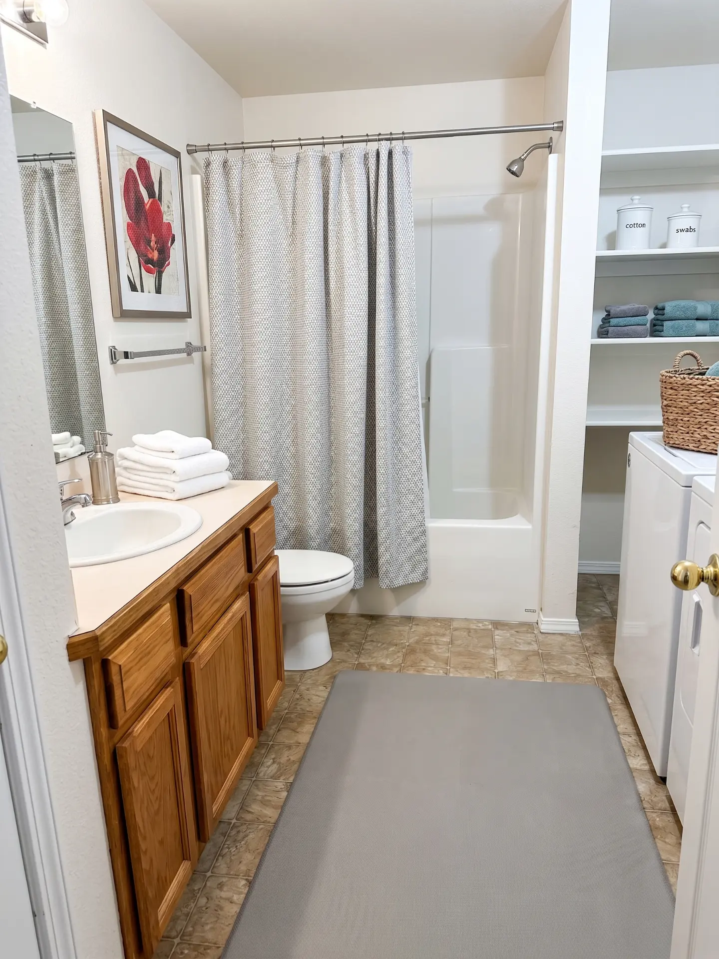 Private rental bathroom with a vanity, toilet, tub-shower, and in-unit laundry